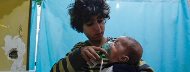 TOPSHOT - A Syrian boy holds an oxygen mask over the face of an infant at a make-shift hospital following a reported gas attack on the rebel-held besieged town of Douma in the eastern Ghouta region on the outskirts of the capital Damascus on January 22, 2018.
At least 21 cases of suffocation, including children, were reported in Syria in a town in eastern Ghouta, a beleaguered rebel enclave east of Damascus, an NGO accusing the regime of carrying out a new chemical attack said. Since the beginning of the war in Syria in 2011, the government of Bashar al-Assad has been repeatedly accused by UN investigators of using chlorine gas or sarin gas in sometimes lethal chemical attacks.
/ AFP PHOTO / HASAN MOHAMED